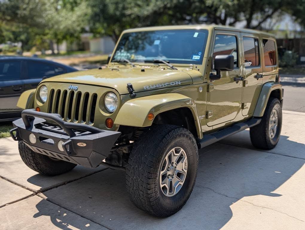 Green Jeep Wrangler Rubicon parked on a driveway.