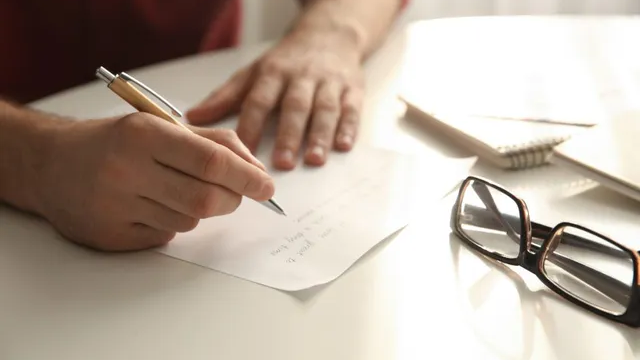 Photo of person hand writing a letter