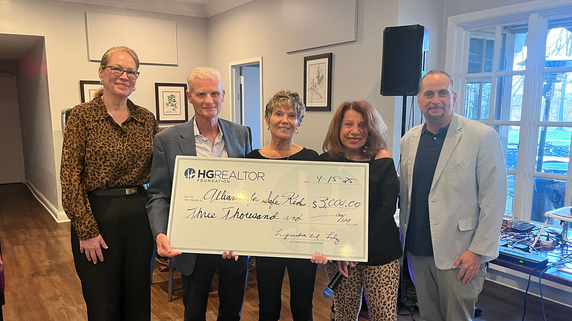 A group of people are standing next to each other holding a large check.