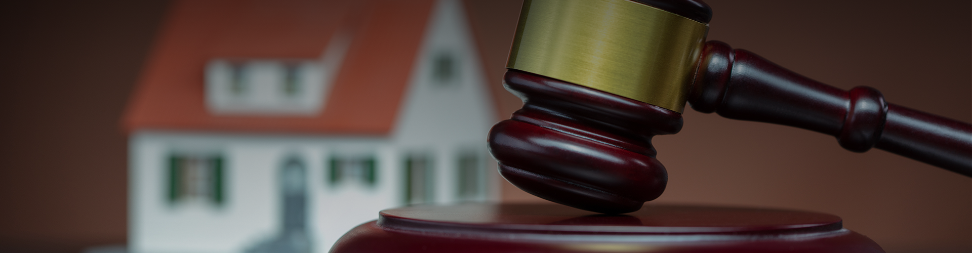 A judge 's gavel is sitting on a table in front of a small house.