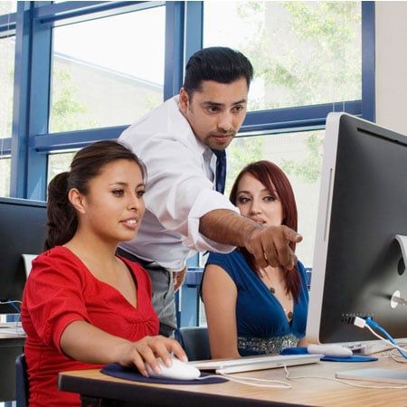 student learning at a computer with instructor