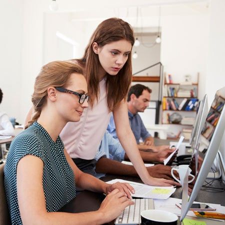 student learning at a computer with instructor