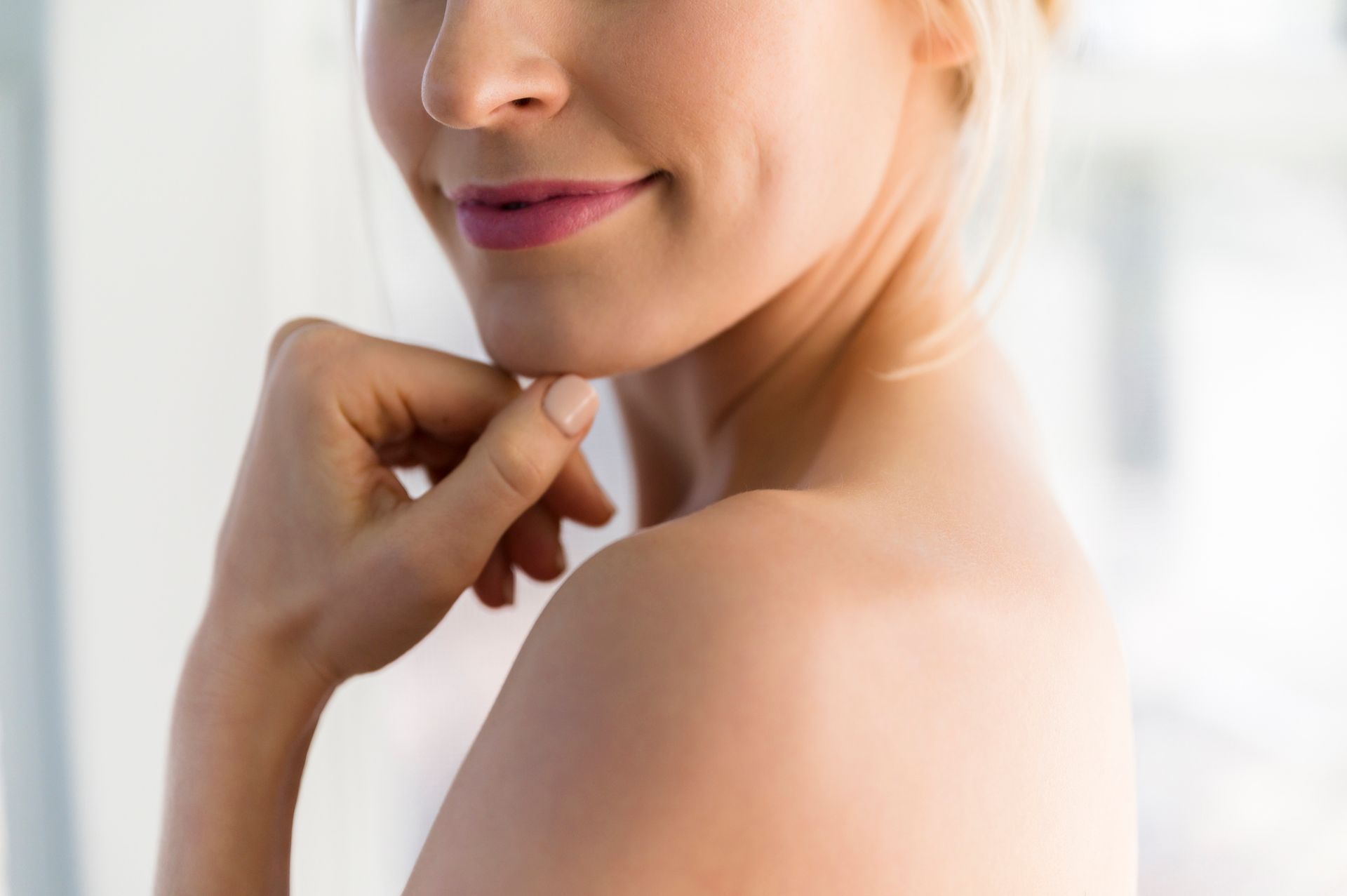 A close up of a woman 's face with her hand on her chin.