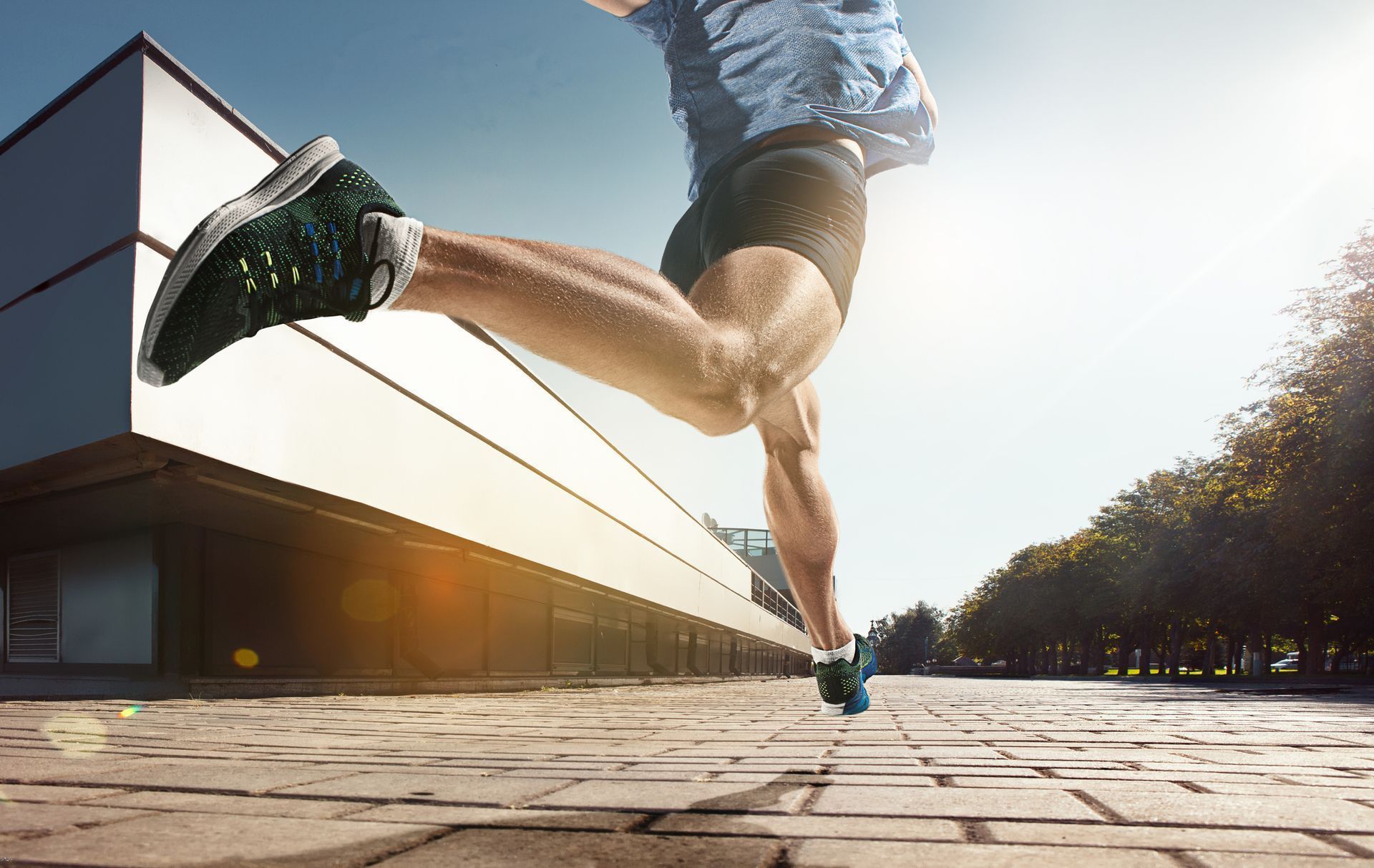 A person is running on a brick sidewalk in front of a building.
