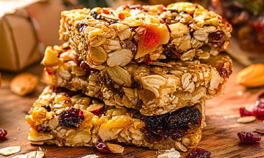 Granola bars stacked on top of each other on a wooden table.