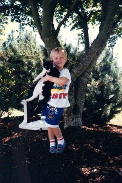 Young Kyle Kocsis holding cat