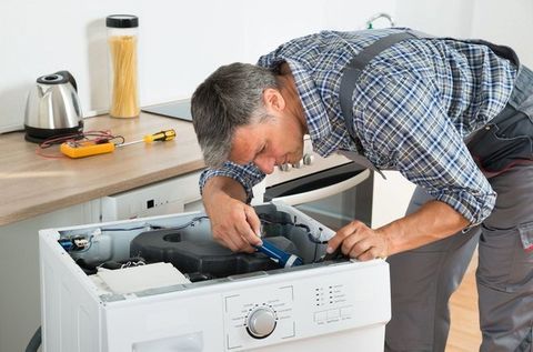 repair man fixing a fridge