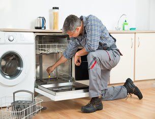 repair man fixing a dishwasher