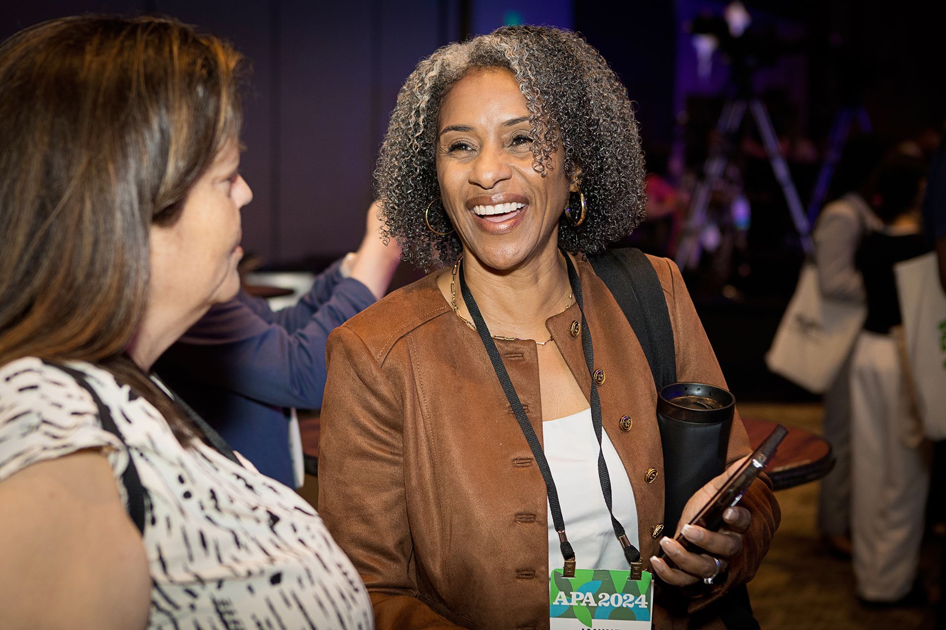 Two women are talking to each other at a conference.