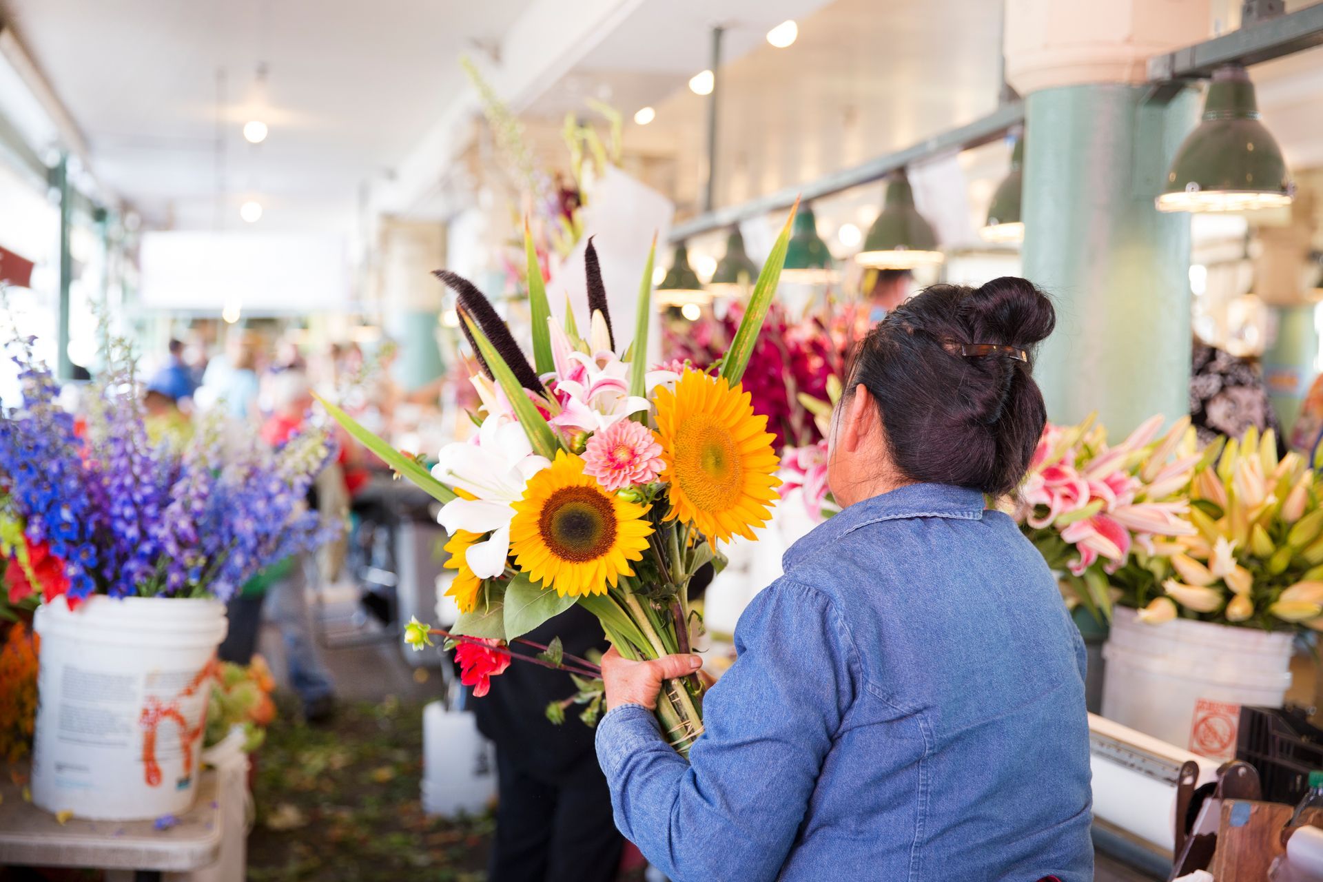 A woman is holding a bouquet of flowers in a flower shop.