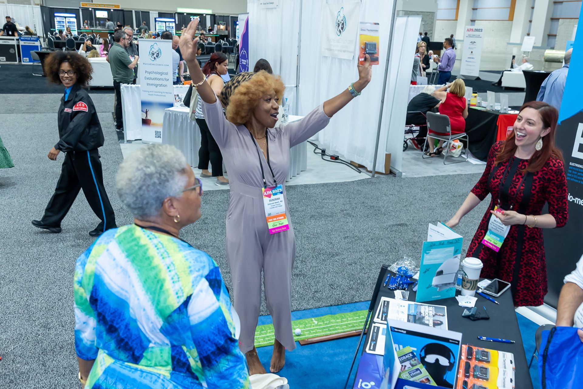 A group of women are standing around a table at a convention.