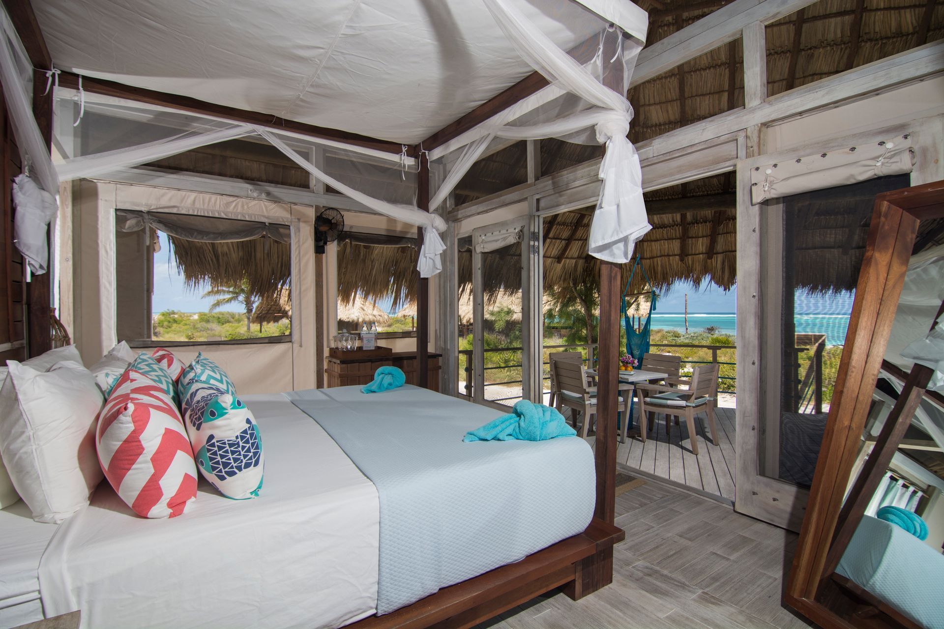 Bedroom with a bed, pillows, and a view of the ocean.