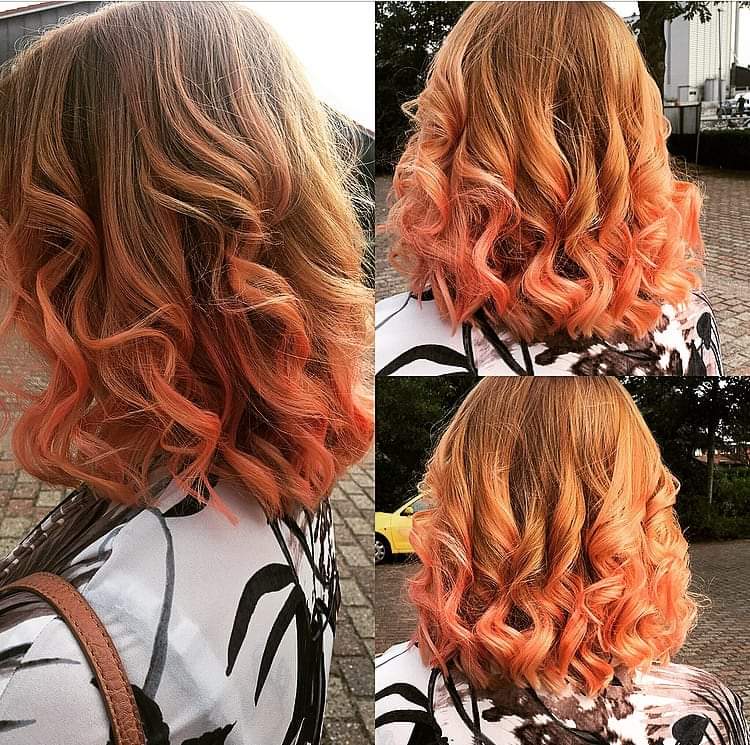 Eine Frau mit orangefarbenen Haaren trägt ein geblümtes Hemd