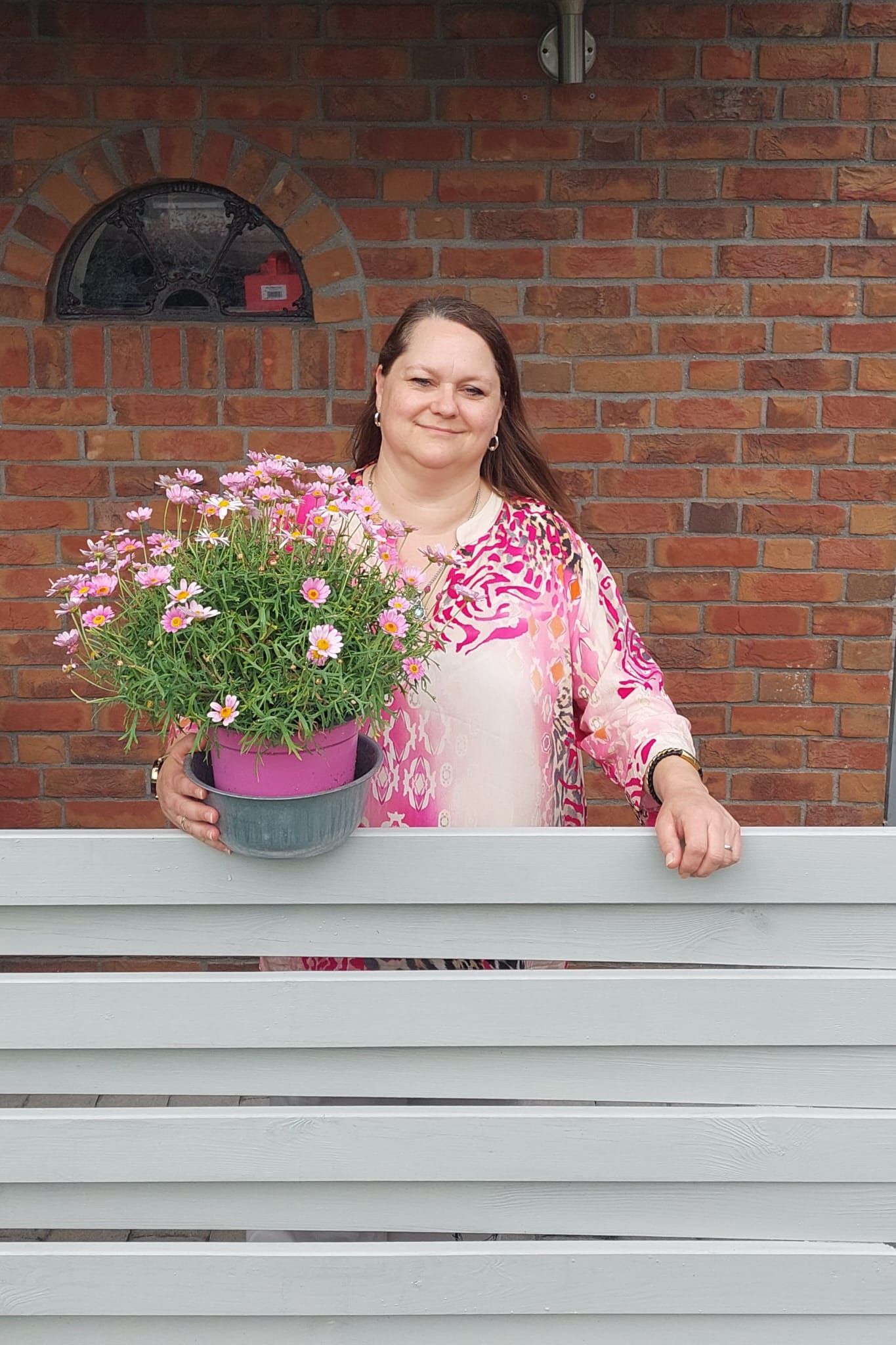 Auf einem Schwarzweißfoto steht eine Frau mit Brille auf einem Feld.