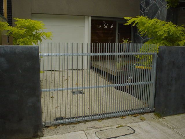 A white garage door is behind a metal gate.