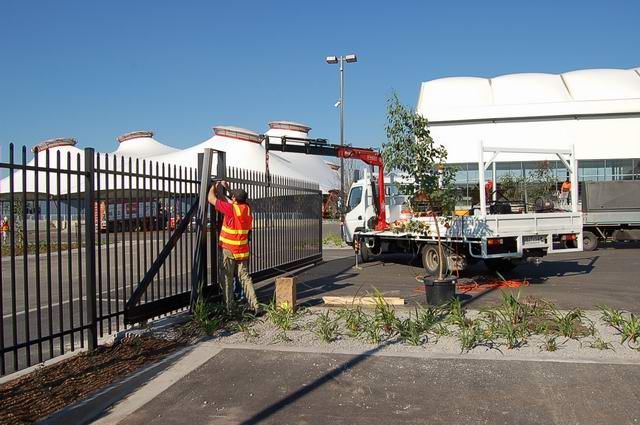 A man is working on a fence next to a truck.