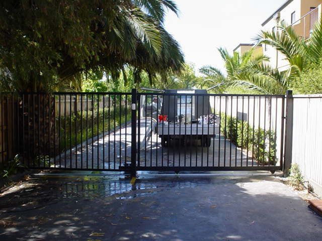 A truck is parked behind a gate in a driveway