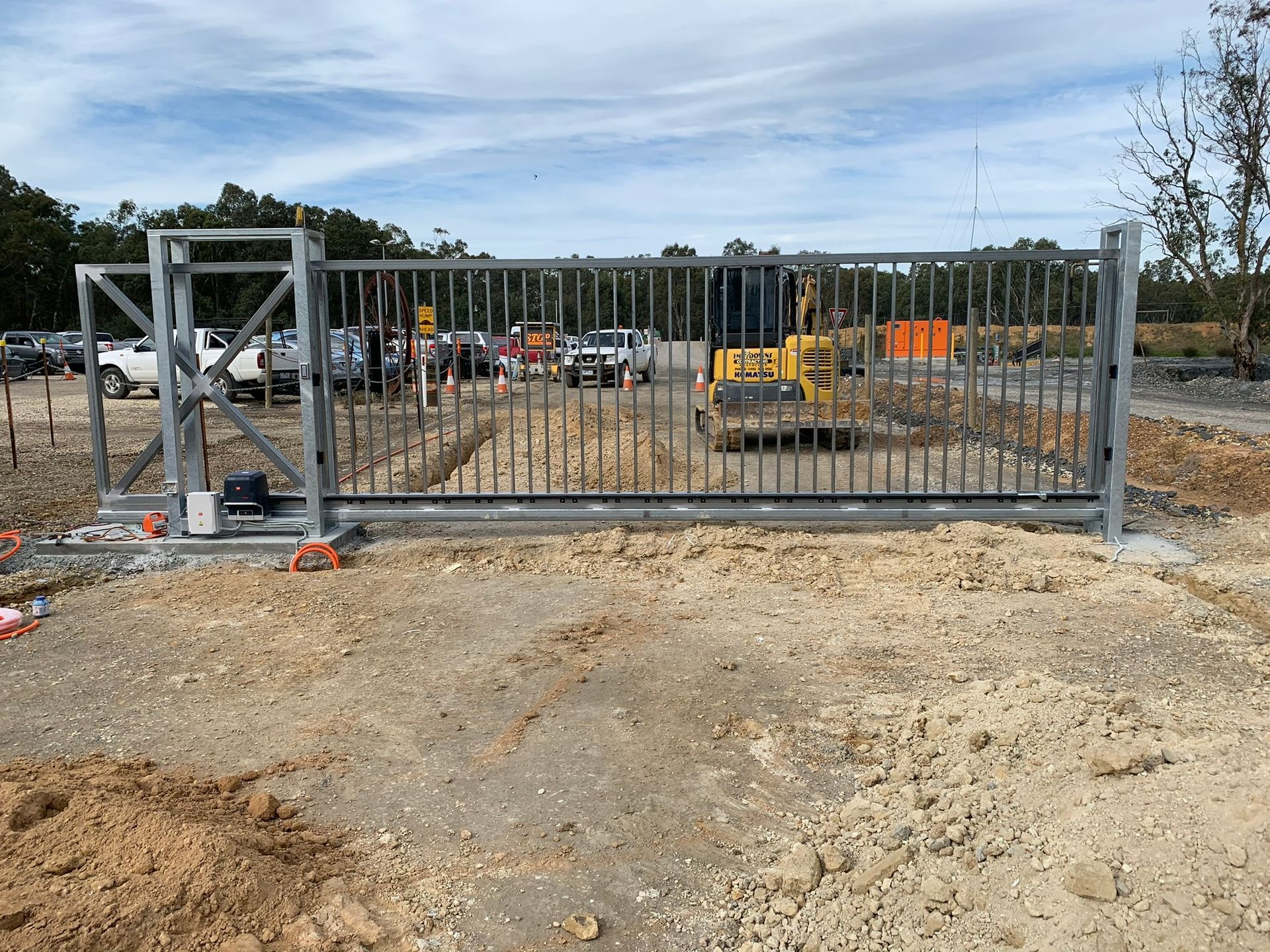 A white truck is parked behind a gate in front of a house
