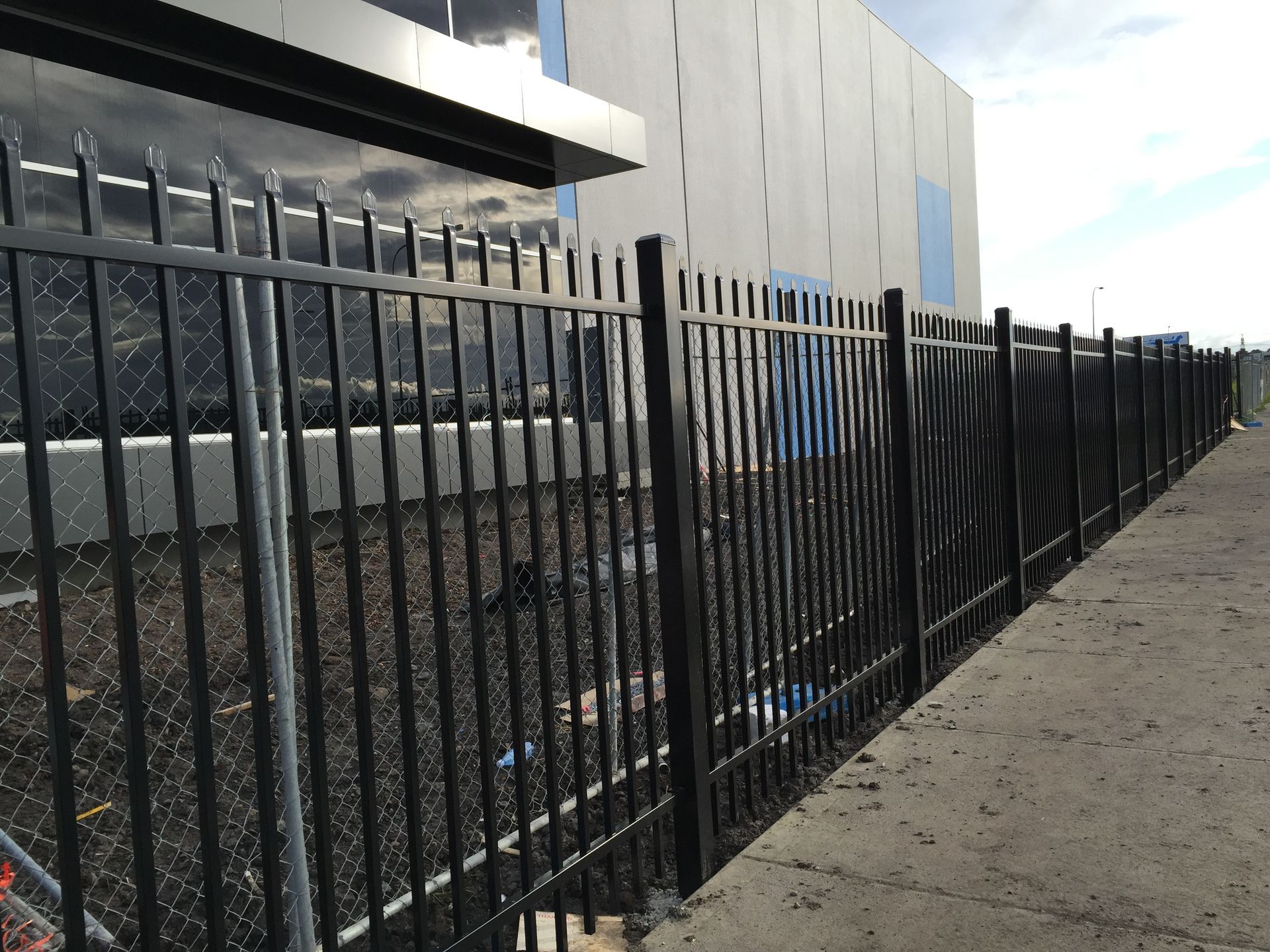 A white picket fence surrounds a lush green garden.