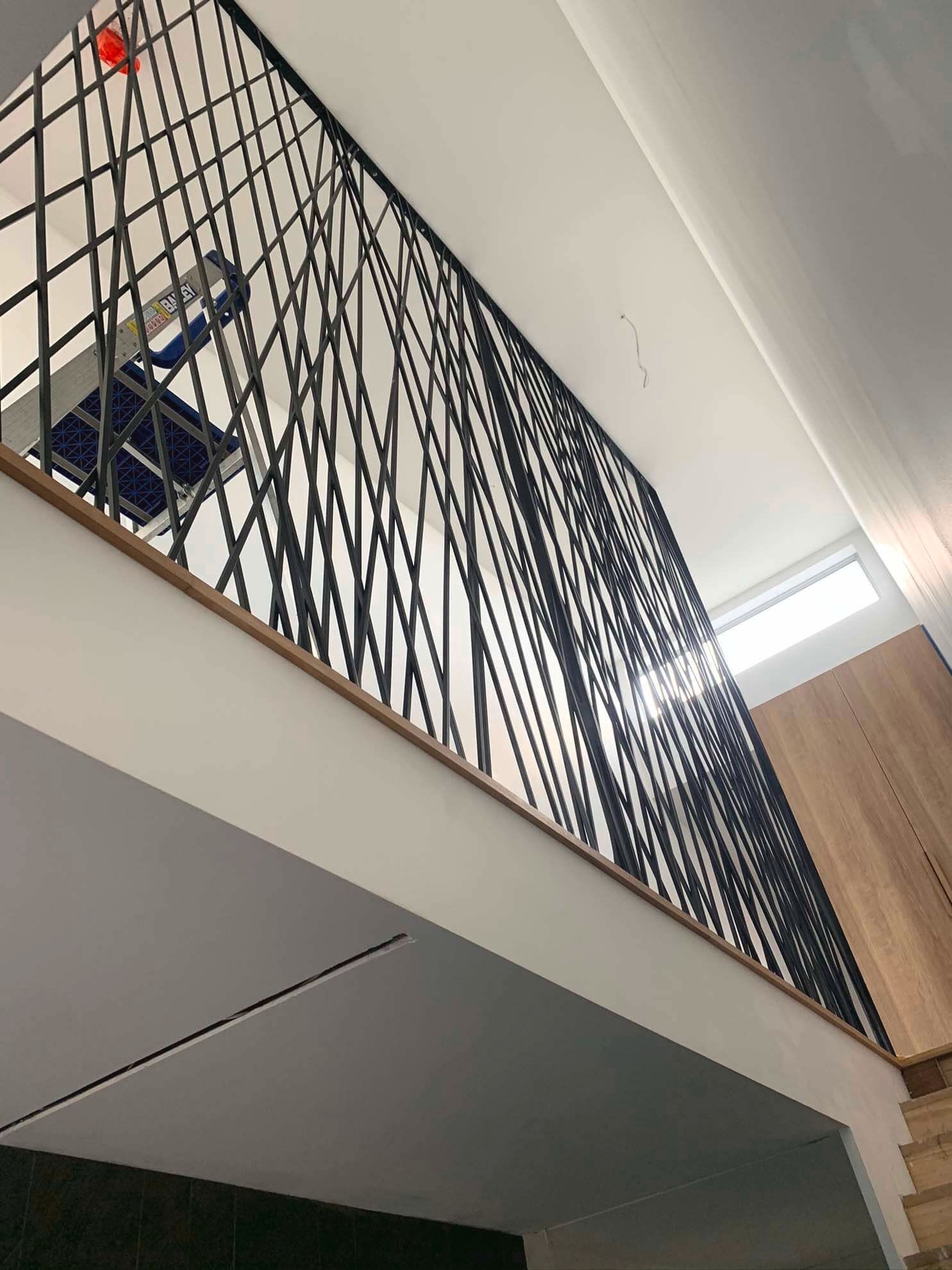 Looking up at a staircase with a wrought iron railing.