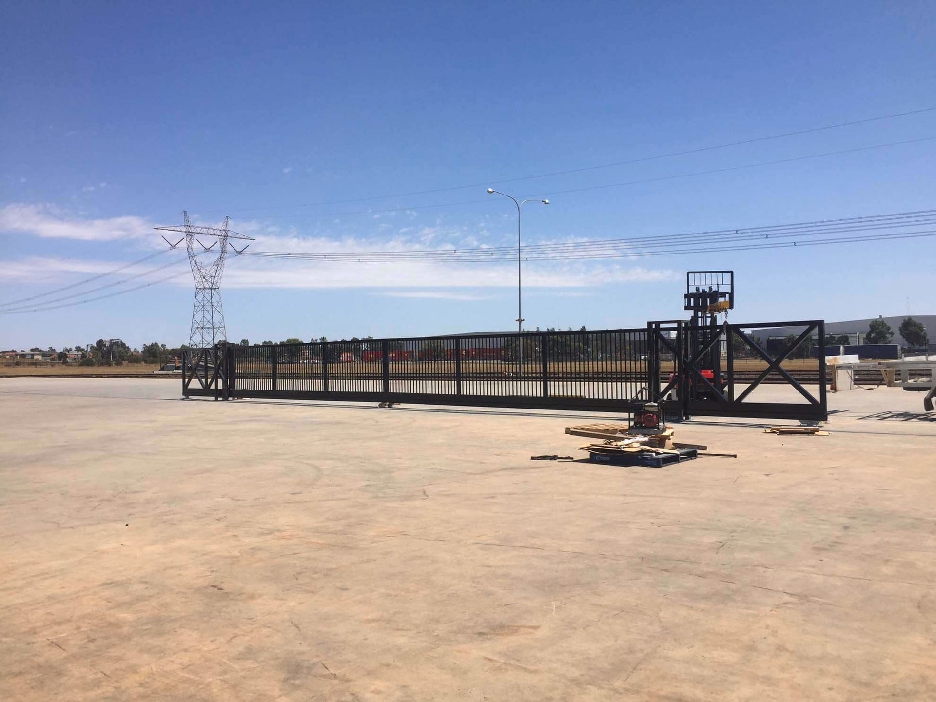 A sliding gate is being built in a parking lot.