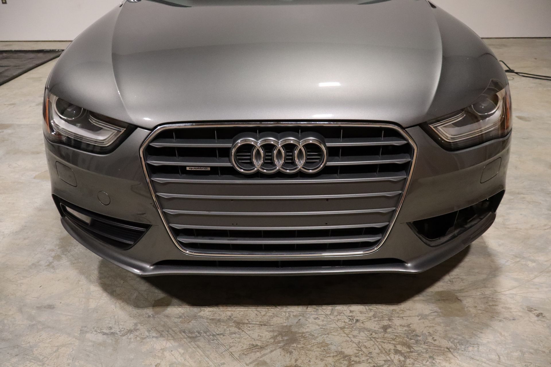 A gray audi a4 is parked in a garage.