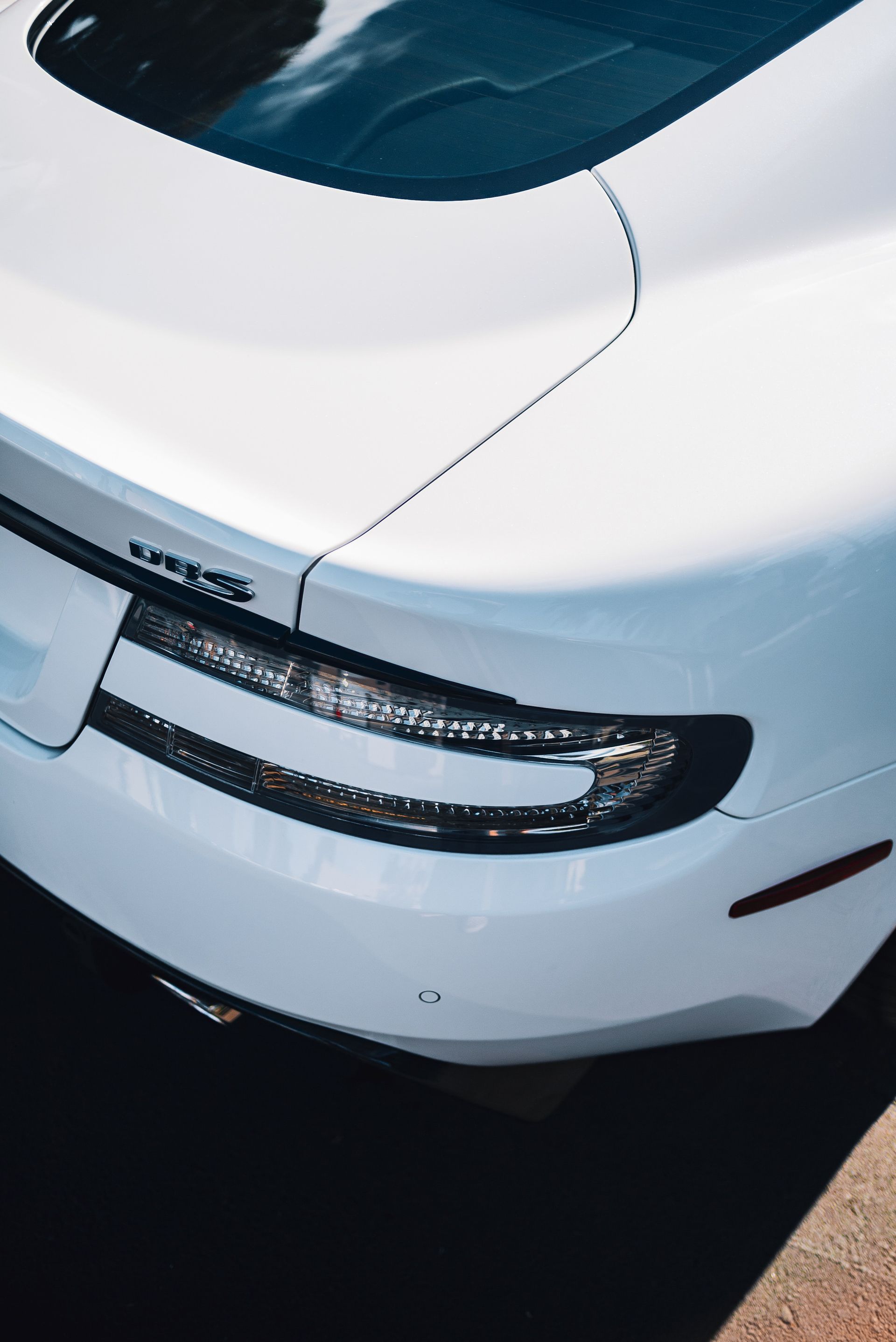 A white sports car is parked on the side of the road.