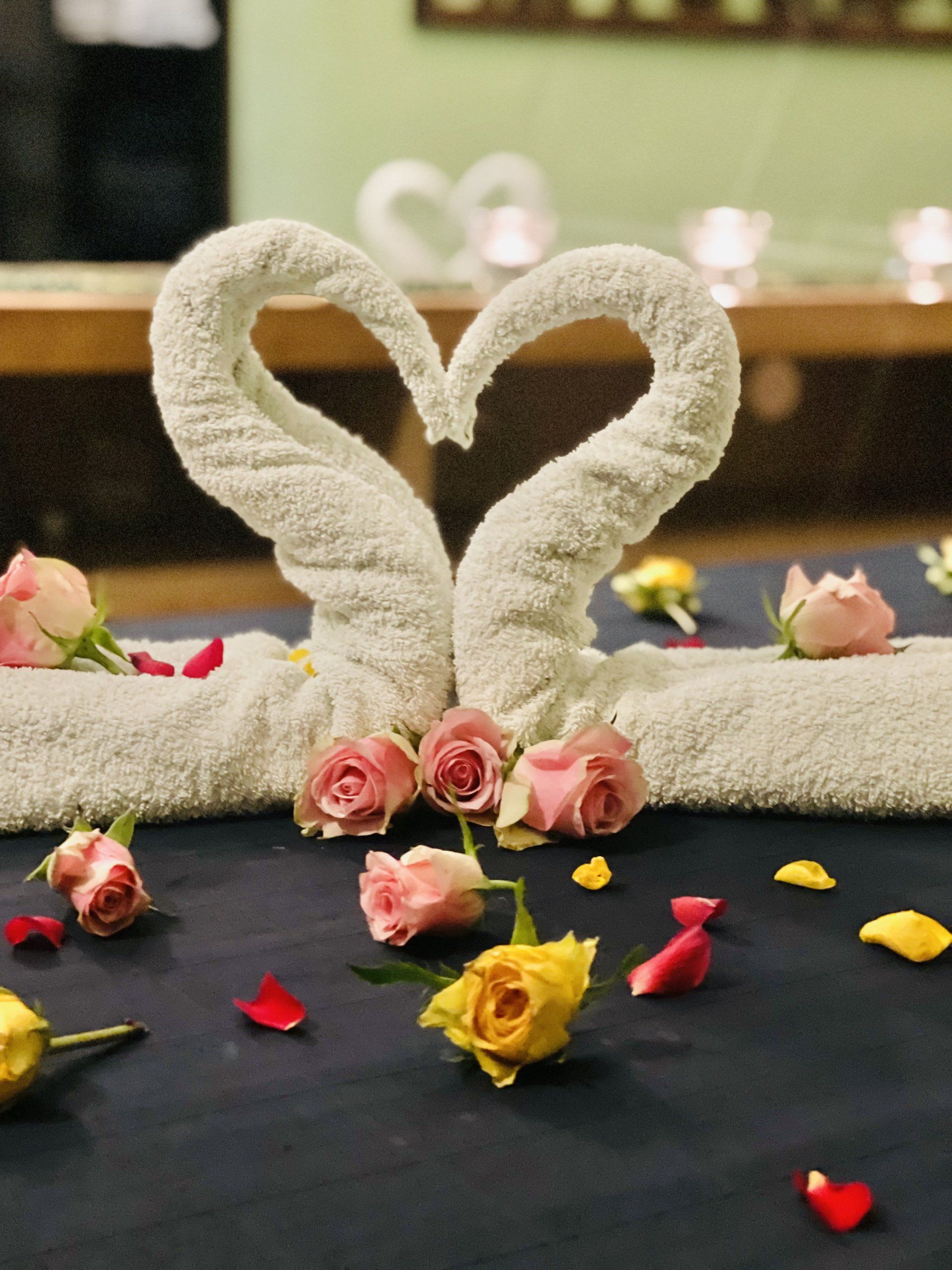 Zwei Handtücher in Form von Schwänen mit Rosen drumherum