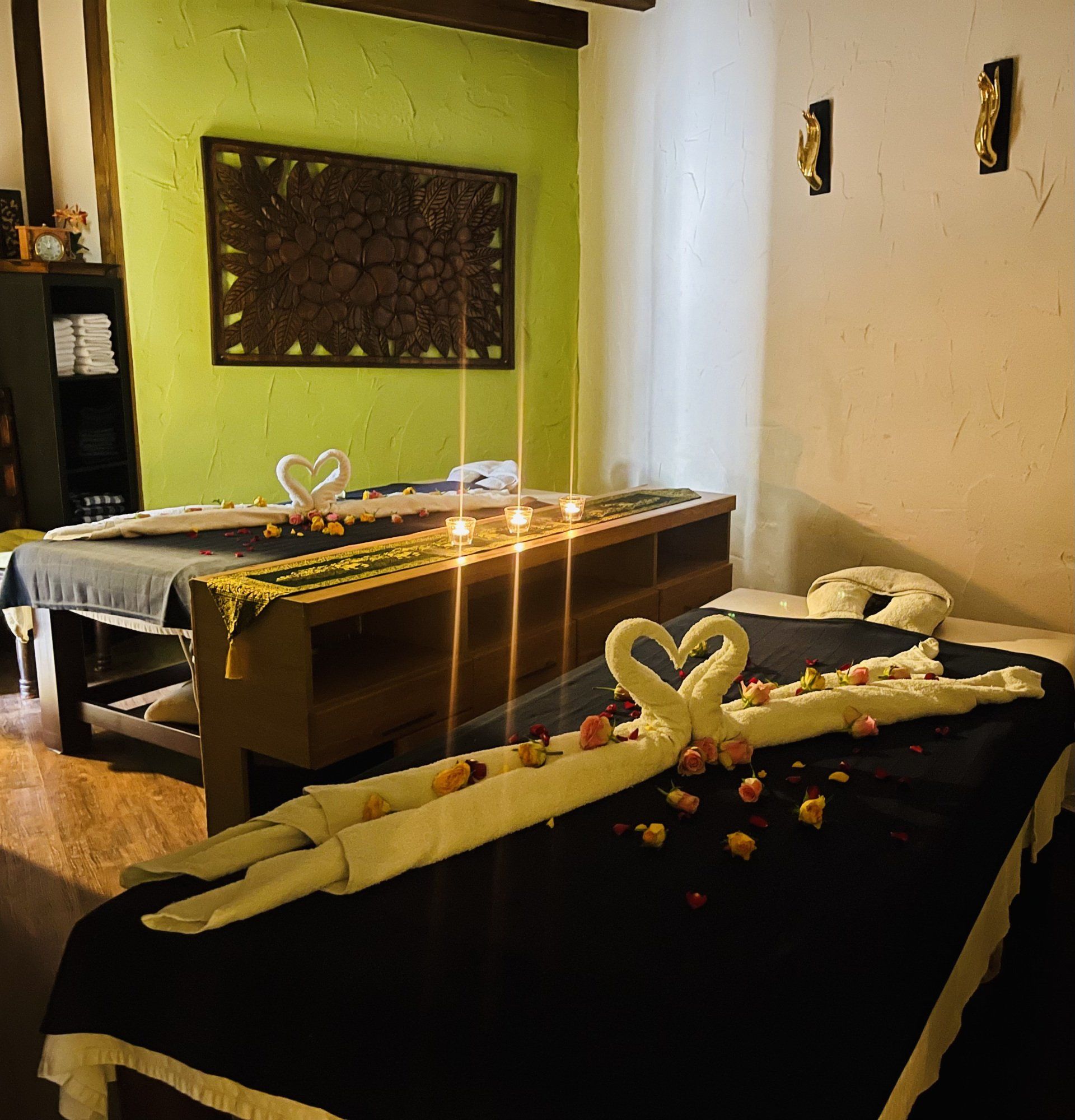 Ein Zimmer mit zwei Betten, dekoriert mit Handtüchern und Kerzen