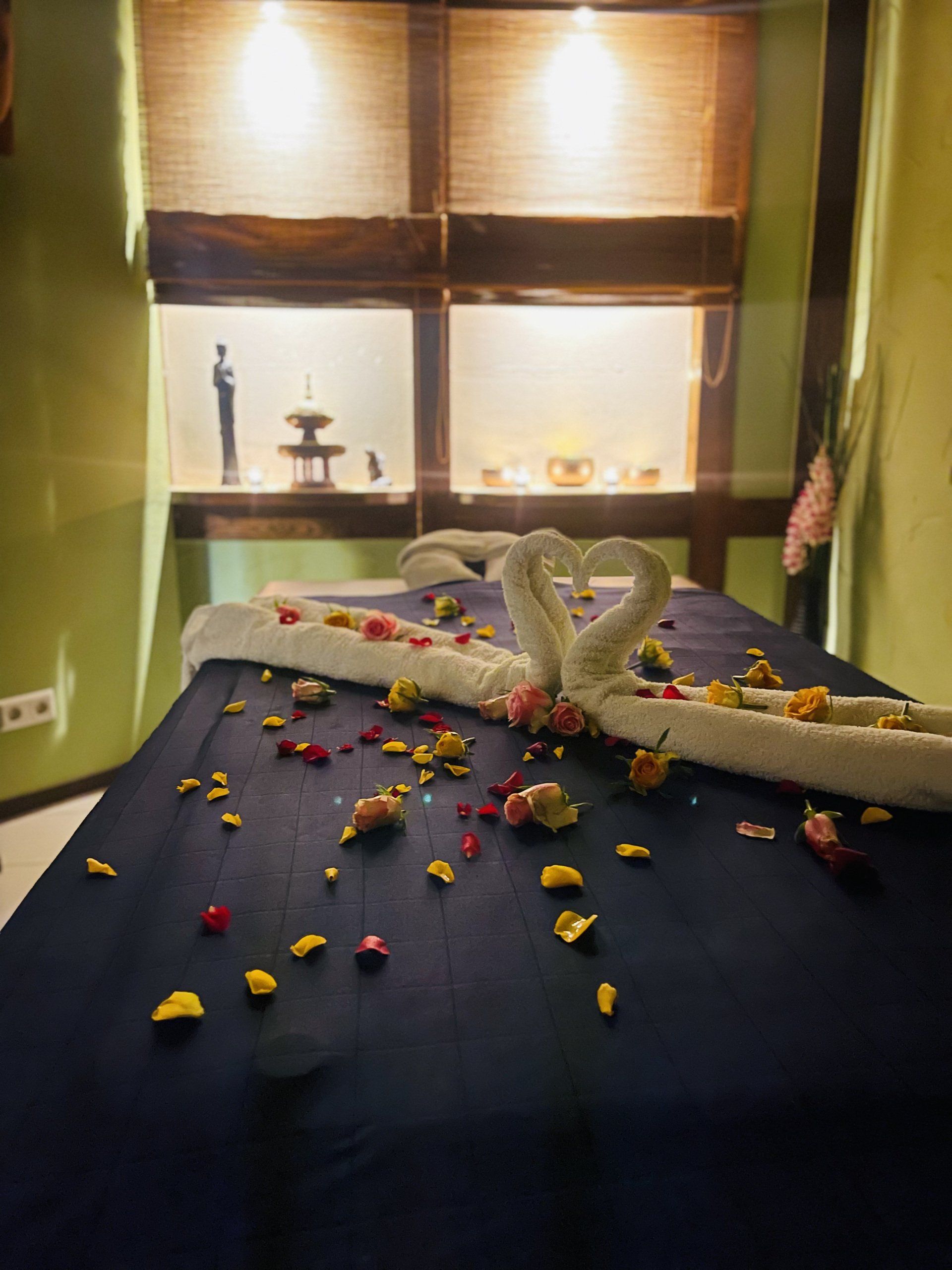 Ein Tisch mit zwei Schwänen aus Handtüchern und Blumen darauf.