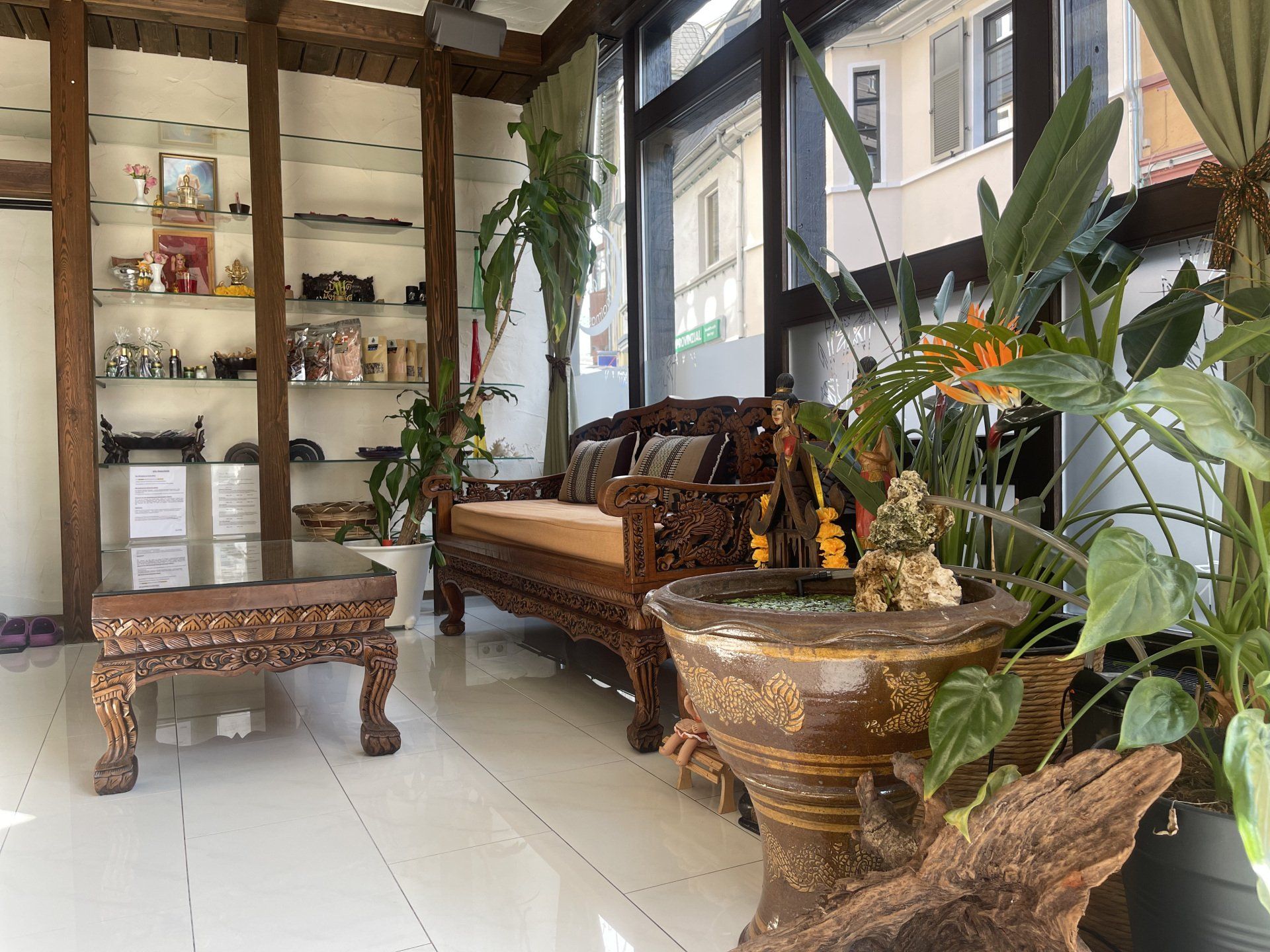 Ein Wohnzimmer mit Couch, Tisch und Topfpflanzen.