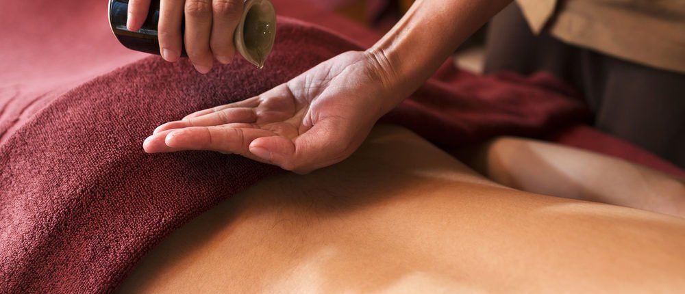 Eine Person bekommt eine Rückenmassage mit Öl.
