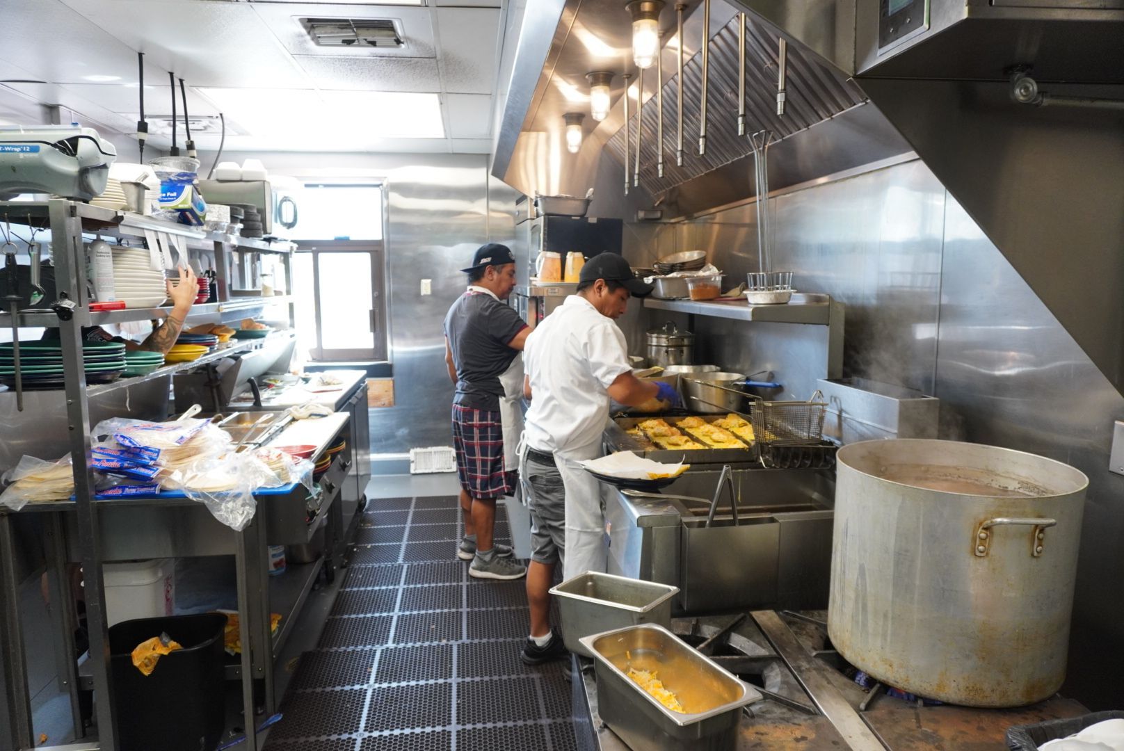 A restaurant with tables and chairs and a clock on the wall.