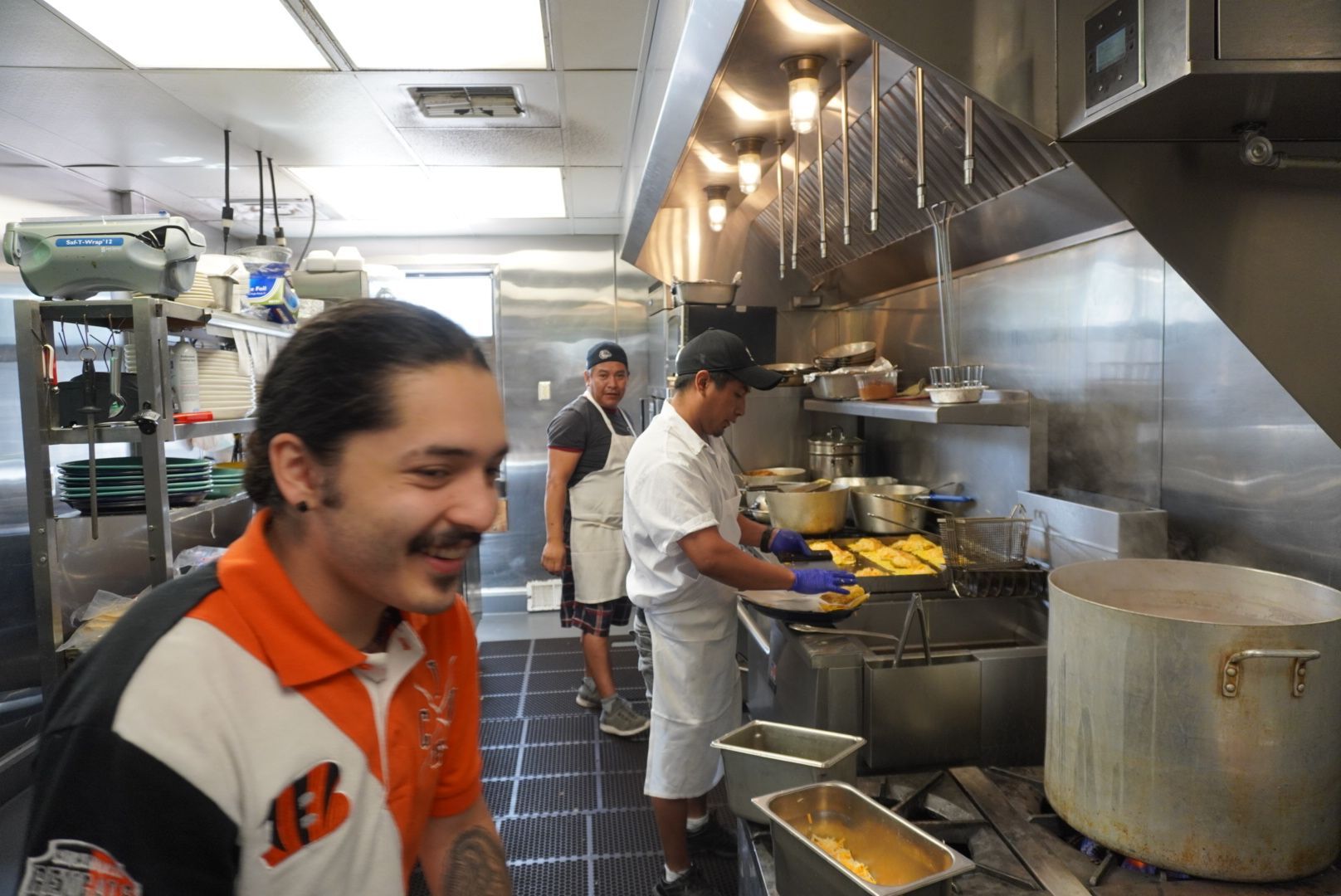 A man is cooking on a stove that says imperial
