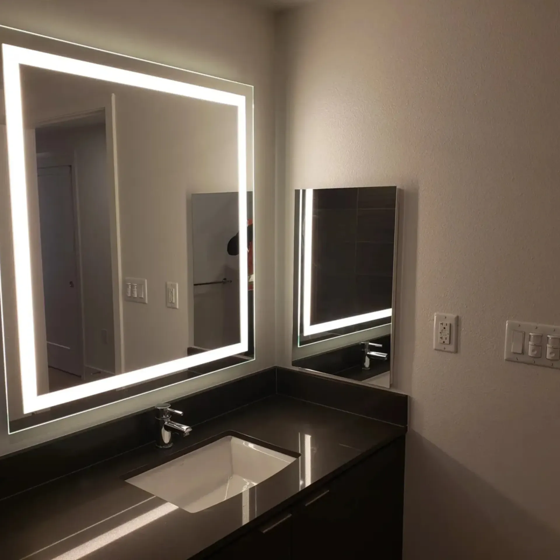 OE Services LLC - A bathroom with two mirrors and a sink