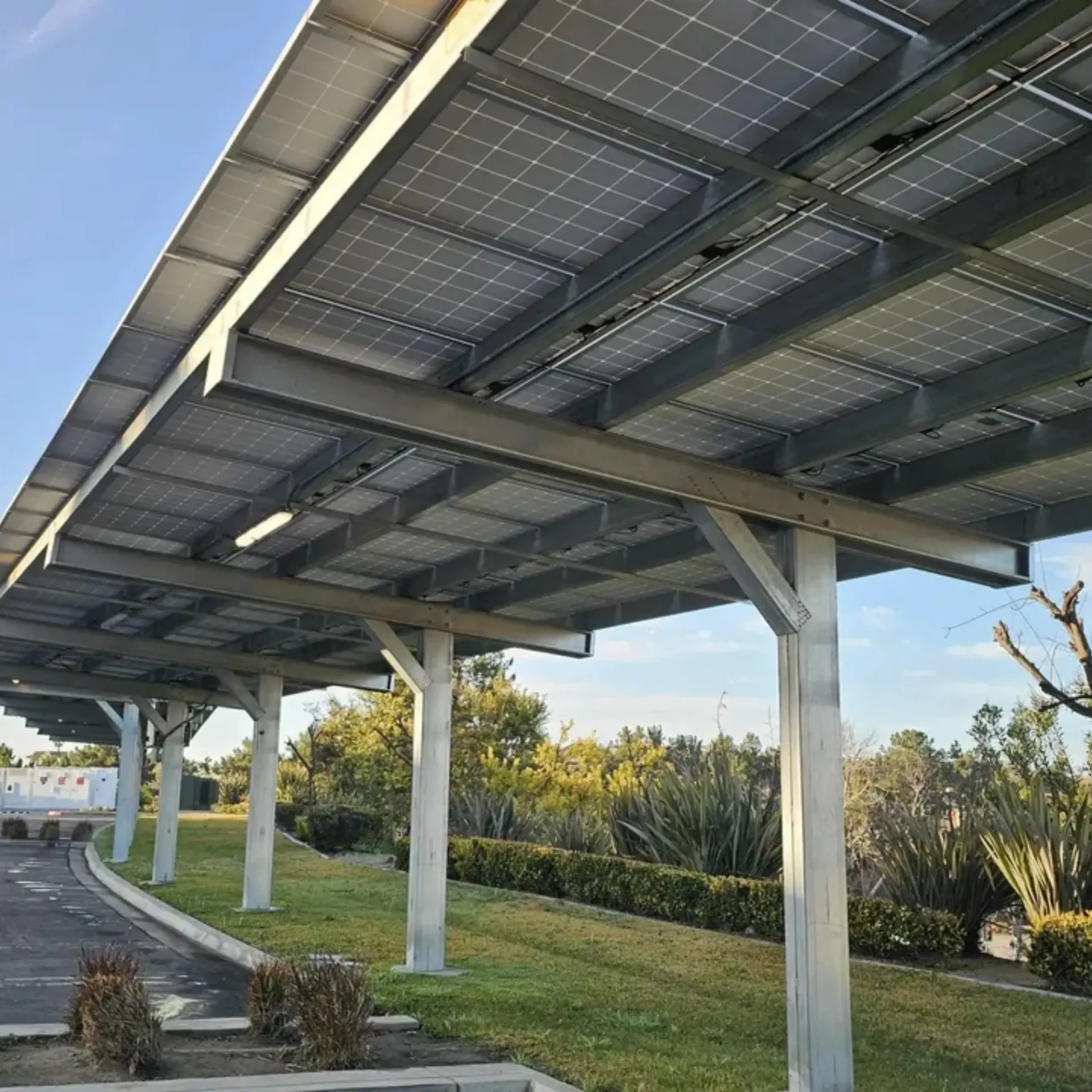 OE Services LLC - A row of solar panels under a canopy on a sunny day