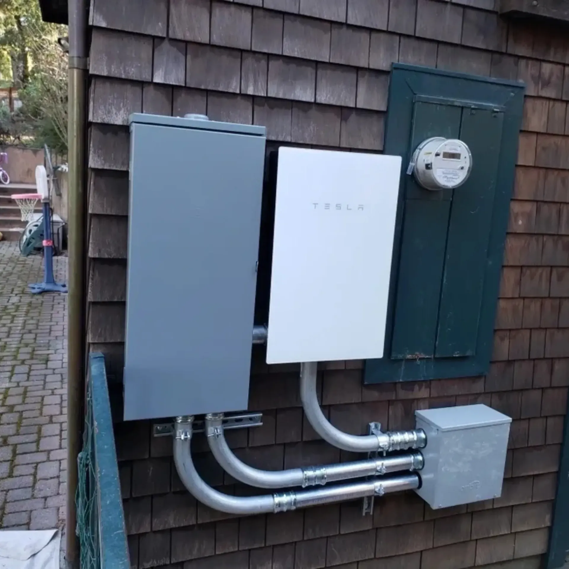 OE Services LLC - A tesla solar panel is mounted on the side of a house