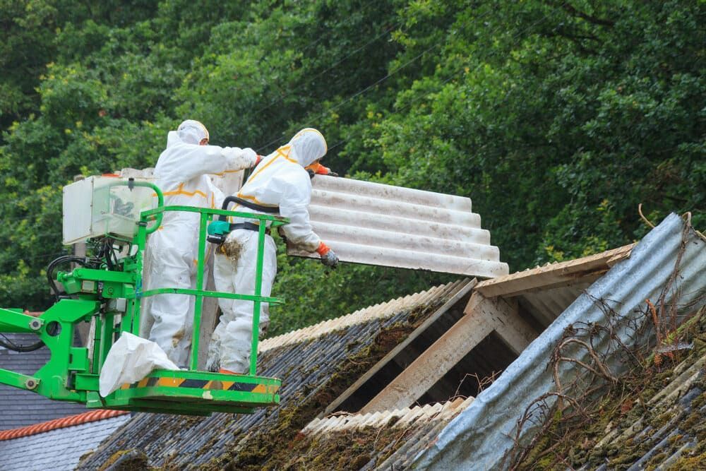 Two Men in Protective Suits Are Working on a Roof — Precise Plumbing & Excavations Pty Ltd in Bowen, QLD