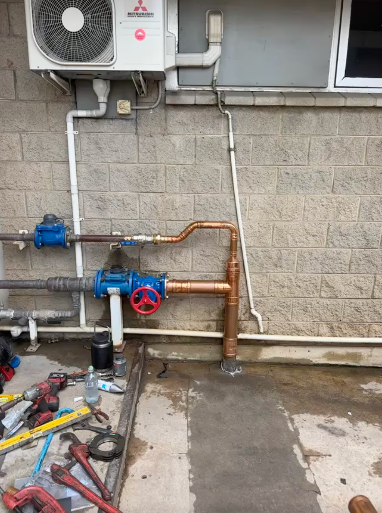 A Plumber is Working on a Boiler With a Screwdriver — Precise Plumbing & Excavations Pty Ltd in Bowen, QLD