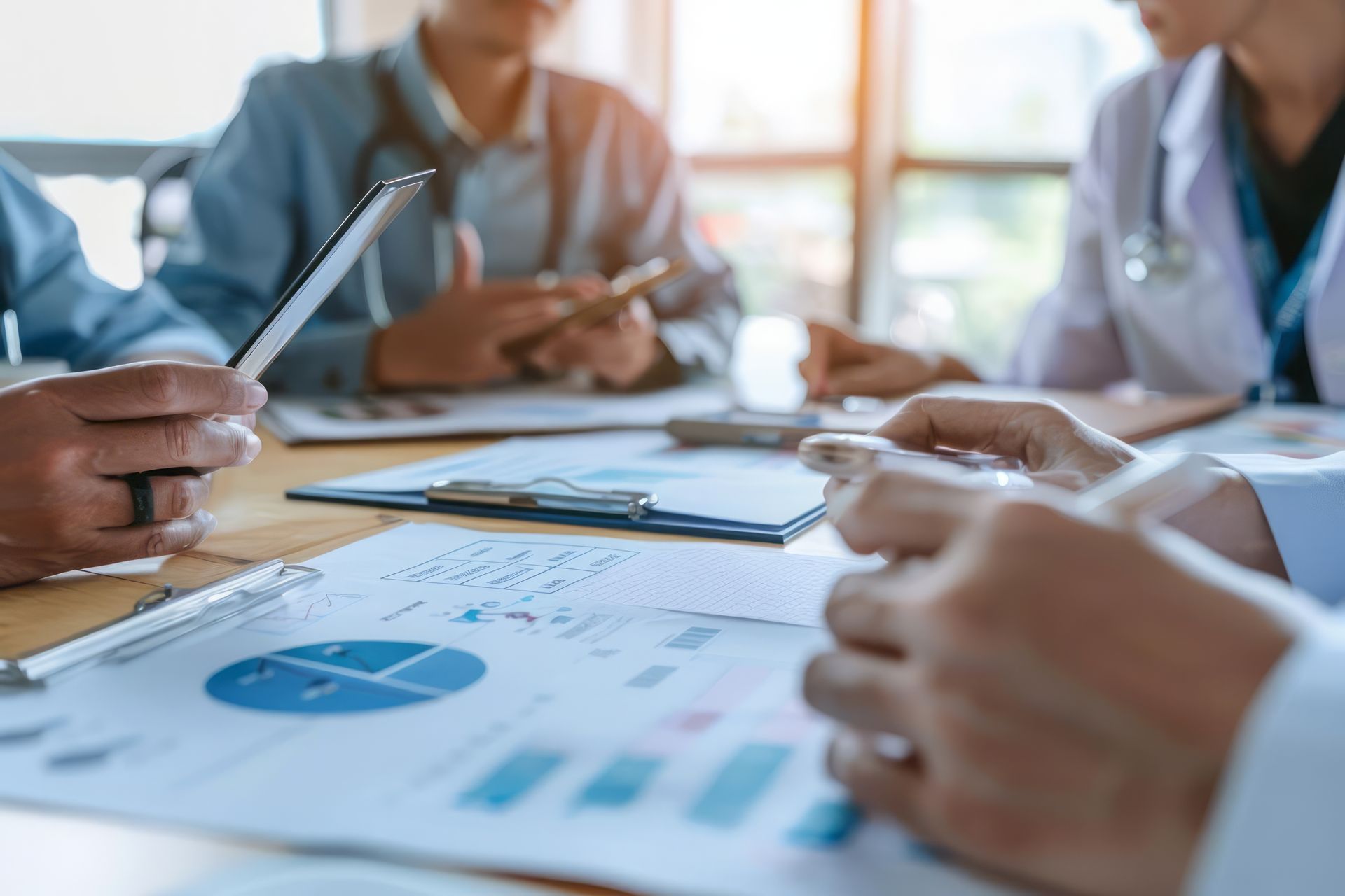 A group of doctors are sitting around a table having a meeting.