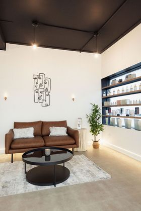 a living room with a brown couch and a black coffee table .