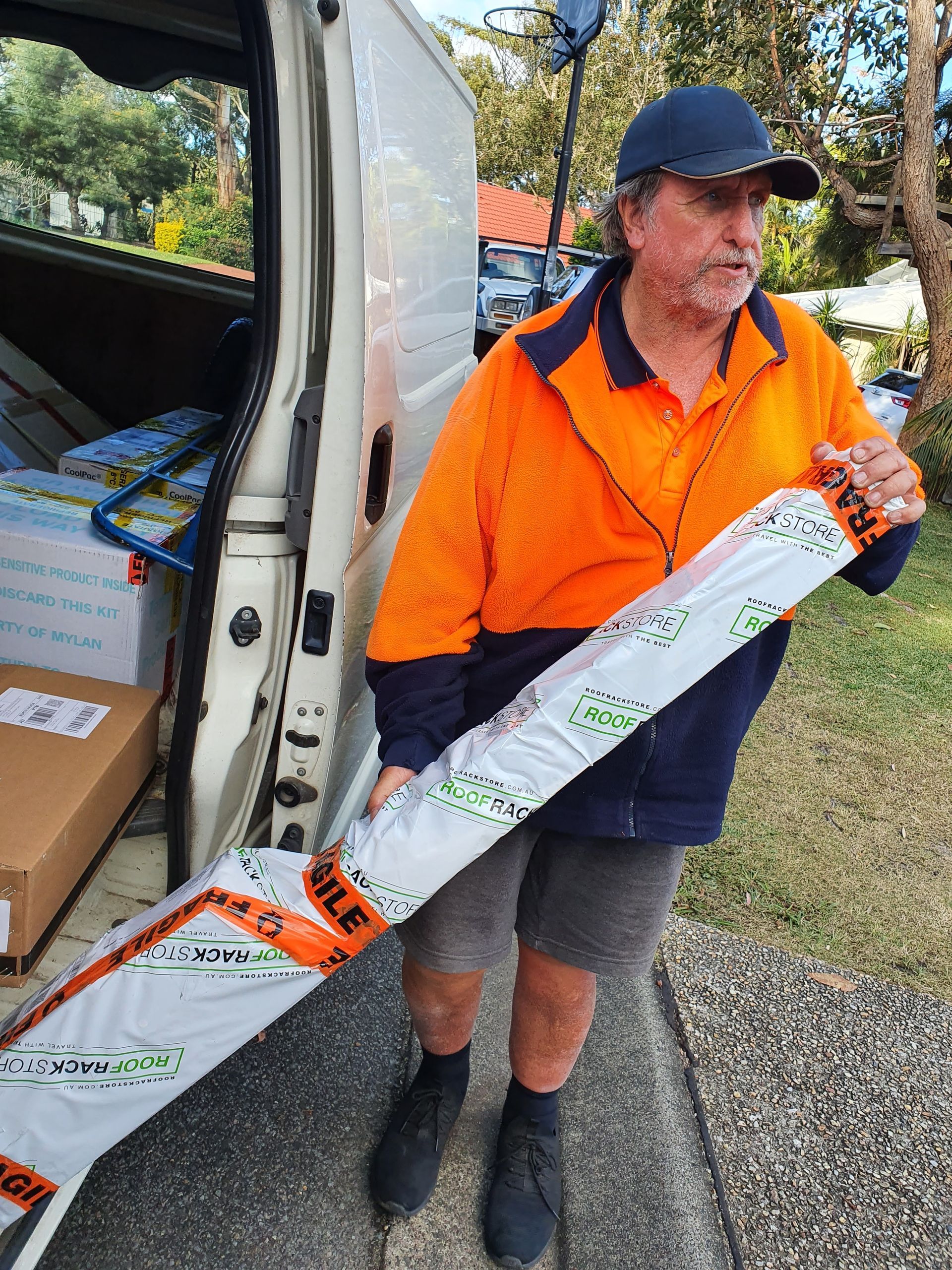 Delivery Worker Holding Boxes Beside a White Van — Access Couriers in Port Macquarie, NSW