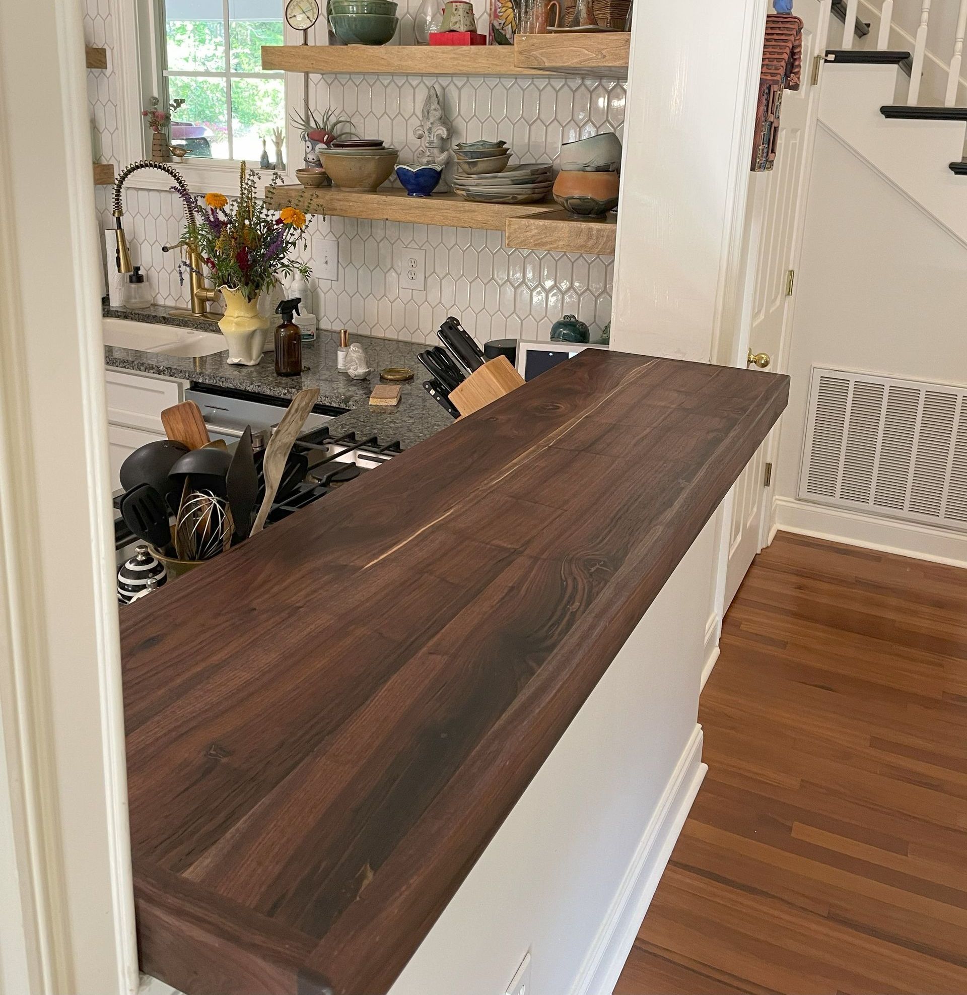 A kitchen with a wooden counter top and shelves