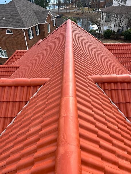 Red tile roof of a house with a central ridge.