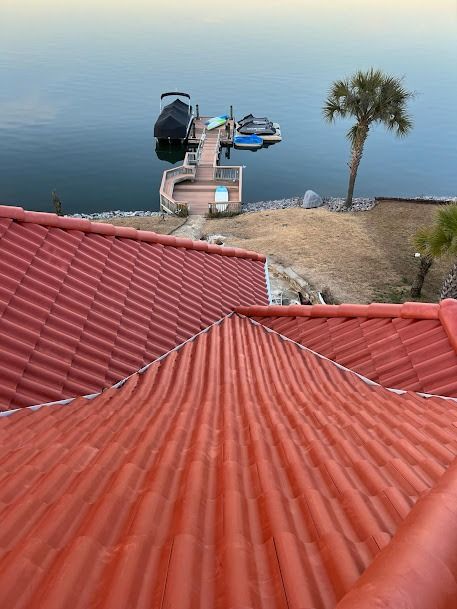 Red tile roof overlooking a dock with boats on a lake at dusk.