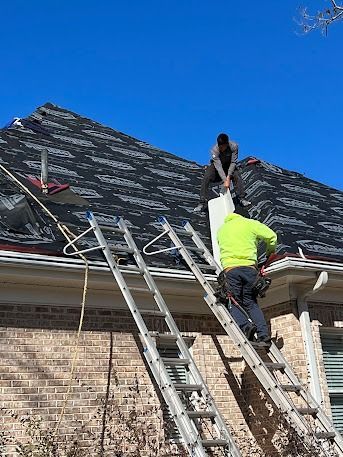 Two roofers on a roof repairing a chimney, sunny day.