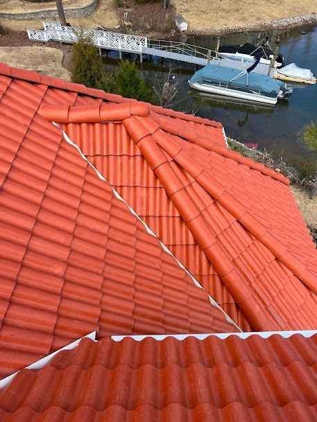 Red tile roof with a view of a lake, boats, and dock.