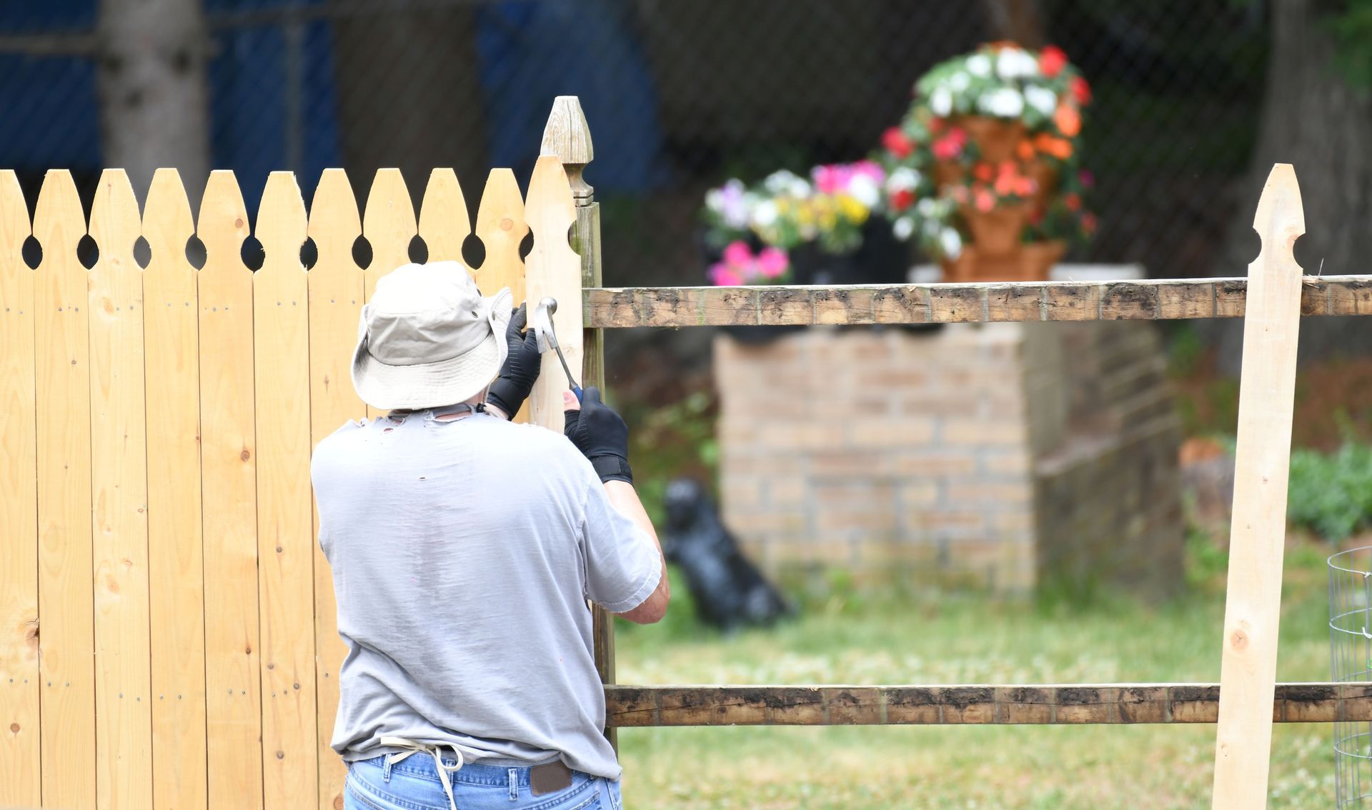 Manual worker installing the wood fence in the yard.