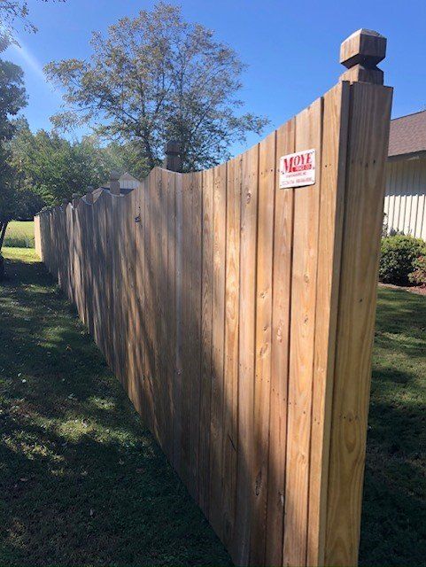Wooden fence with decorative posts in a yard.