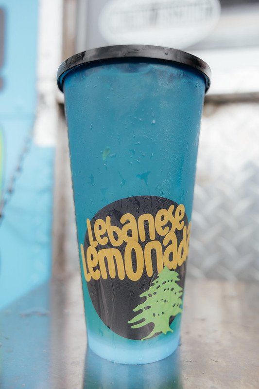 Blue Lebanese lemonade cup with black lid and logo.